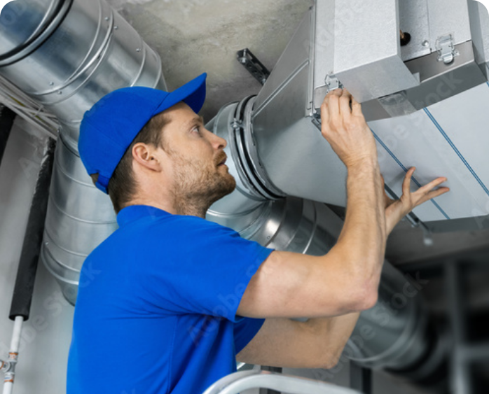 man in blue shirt and hat checking HVAC system - working on duct work