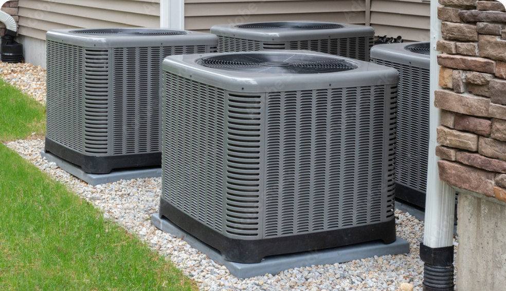 row of residential AC units outside a home with a brick wall and brown siding